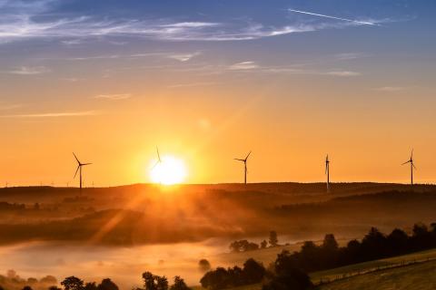 sunrise behind wind turbines