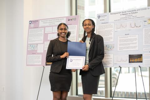 Ariam and Sarah Gebrezgi with their Environmental Justice award certificate in front of their research posters