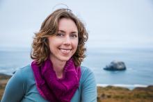 Lynda Hopkins' headshot. Lynda is standing in front of the ocean on the Soonoma coastline