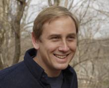 Peter Marra's headshot. Peter is standing in front of trees in winter, he is wearing a blue polo shirt. 