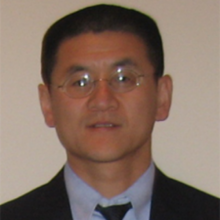 Dr. Zhong's headshot, he is wearing a blue shirt, tie and glasses