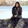 Sherri Mitchell sitting on a rock by a pretty lake